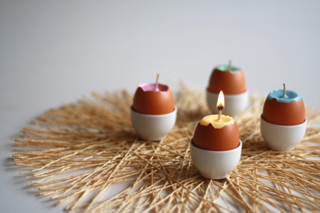 várias velas ecológicas feitas em cascas de ovo em cima de uma mesa